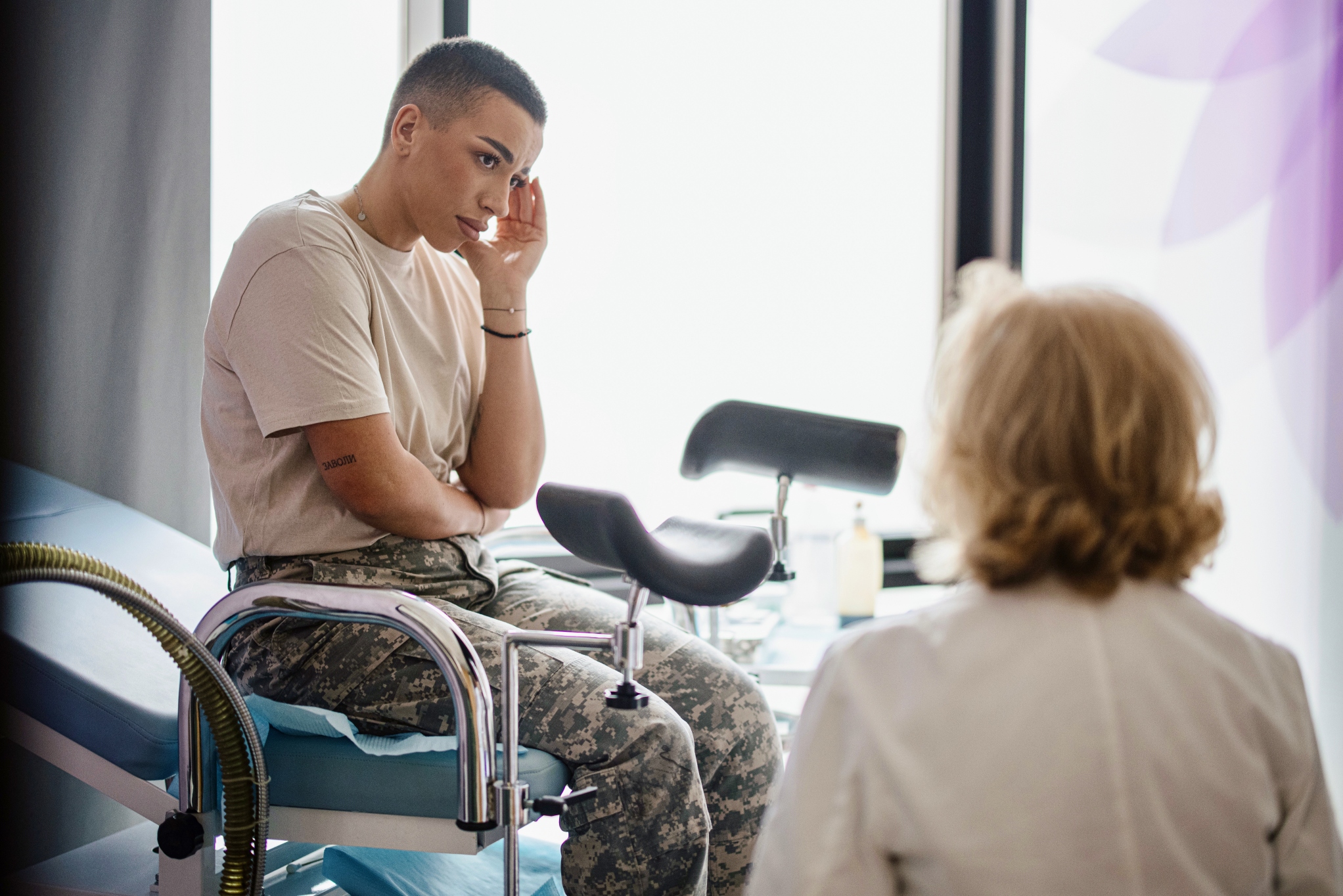 Woman in an exam room with a doctor. 