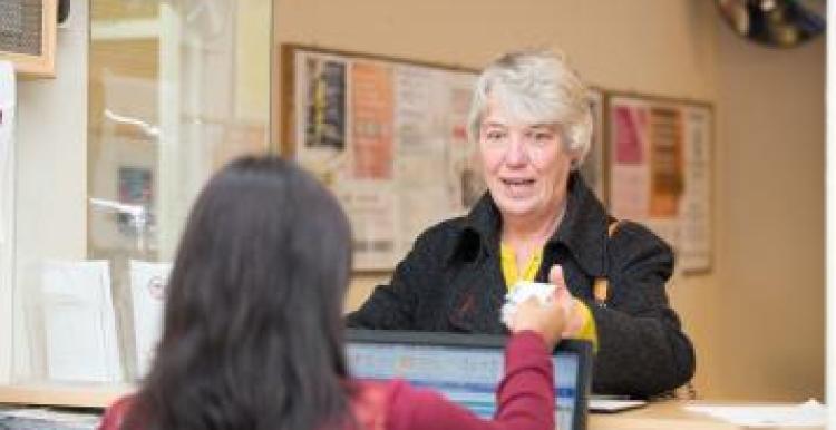 Female patient speaking with a receptionist 