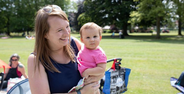Woman and her baby laughing in a park