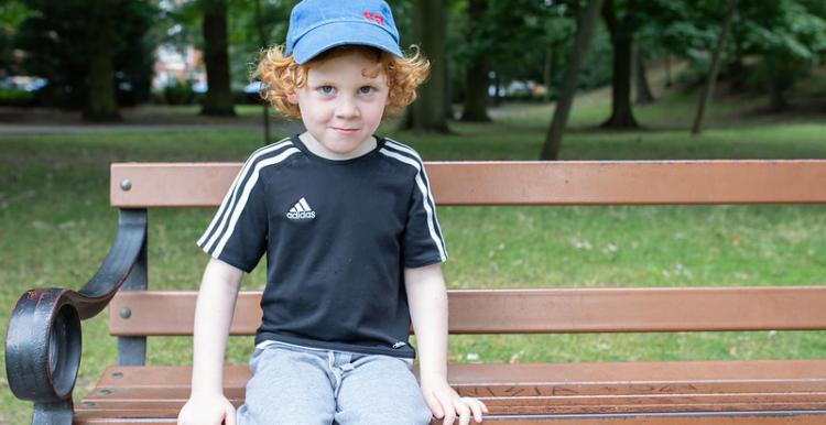 Young boy sitting on a bench