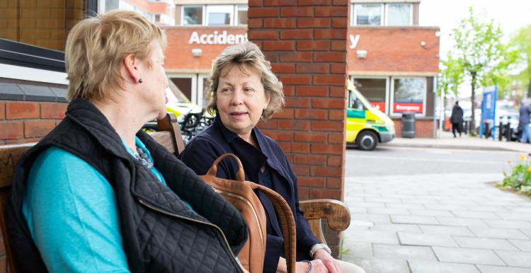 Two_Women_Sitting_Outside_Hosptial_Entrance