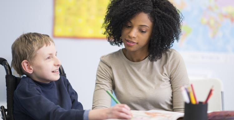 Child with disability being taught how to write