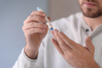 Young male doing a blood finger prick test 