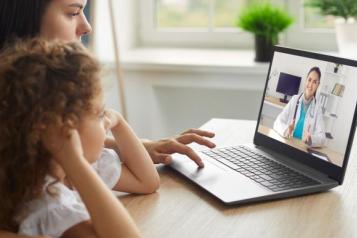 Mother and child having a telemedicine consultation with remote doctor