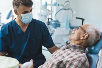 Senior patient sitting in a dental chair whilst waiting for a check up. 