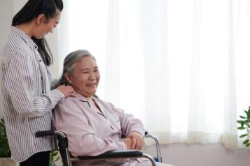 Caregiver talking to senior woman sitting in wheelchair
