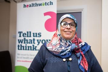 Woman in front of a Healthwatch sign