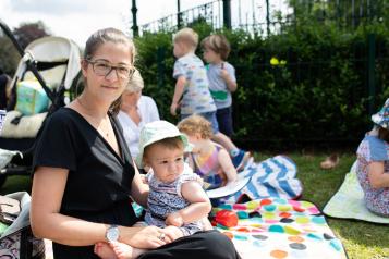 Woman sitting on a picnic blanket with her baby