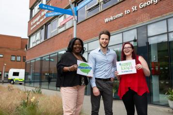 Three people standing outside a hospital encouraging people to speak to Healthwatch 