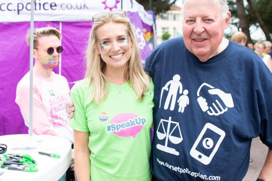 A man and woman standing outside a Healthwatch stand at a community event