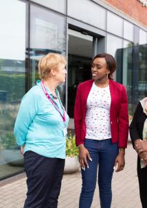Three women standing outside a hospital talking